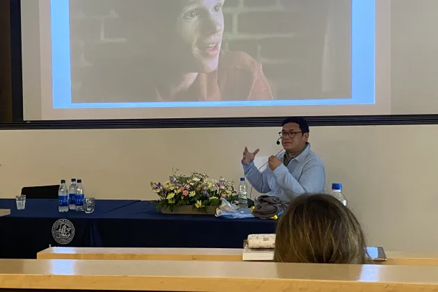 Hario in front of a big screen showing a film