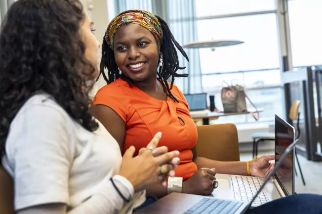Two happy female students talking to eachother