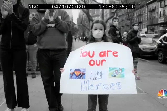 A child holding a sign saying "You are our heroes".