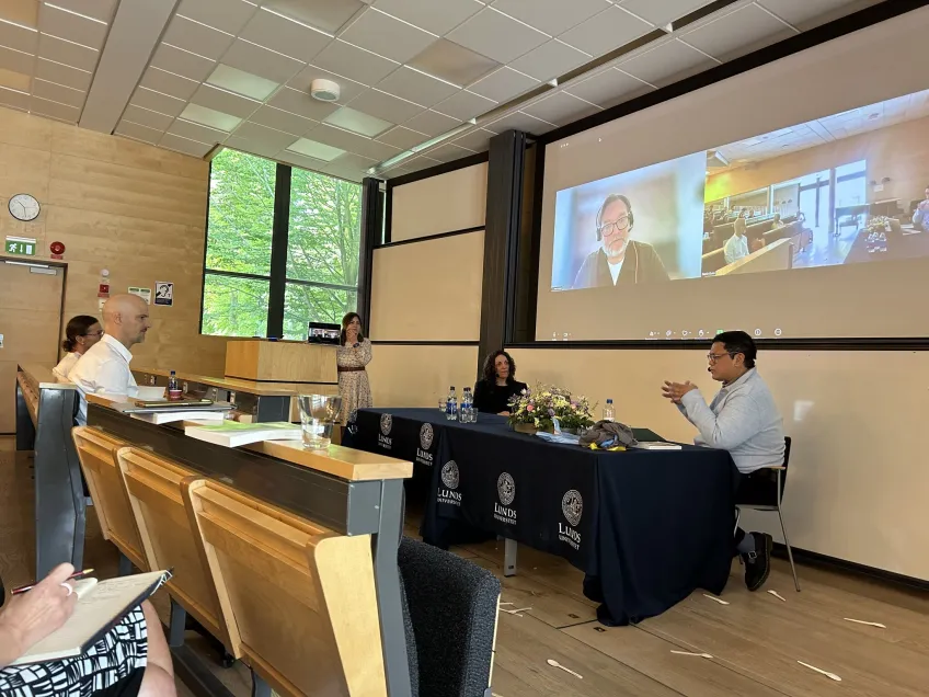 Hario talking to opponent in front of big screen